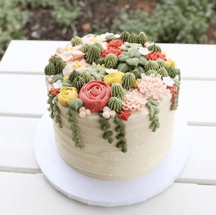 Pastel con frosting de vainilla y adornos de suculentas de betún