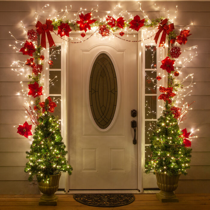 Decoración navideña con luces, pinos y moños rojos