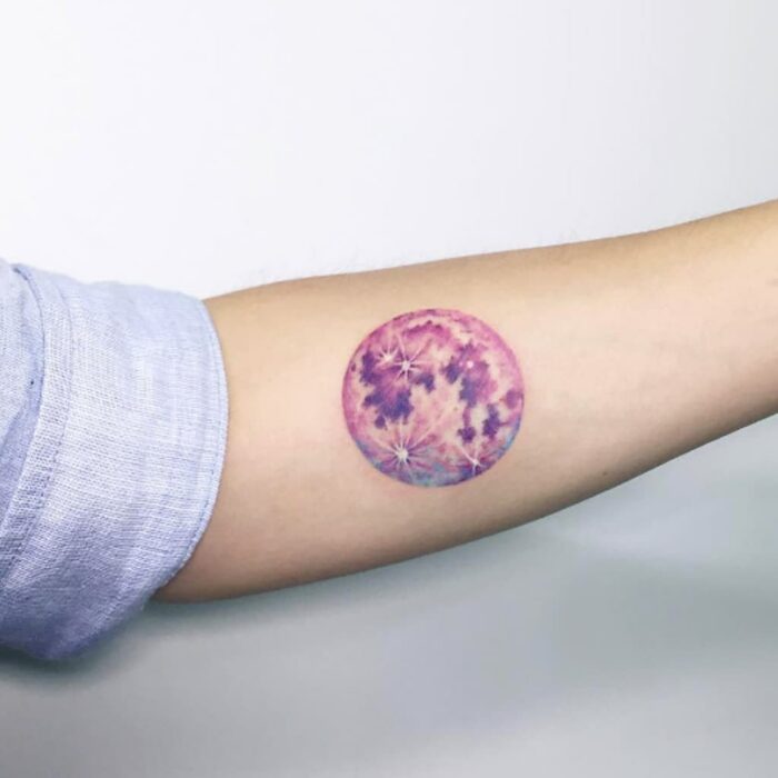 Chica con un tatuaje de color rosa en forma de un círculo con flores
