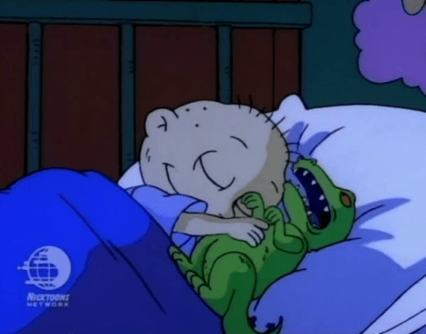 Tommy Pickles dormido abrazando a su muñeco Reptar