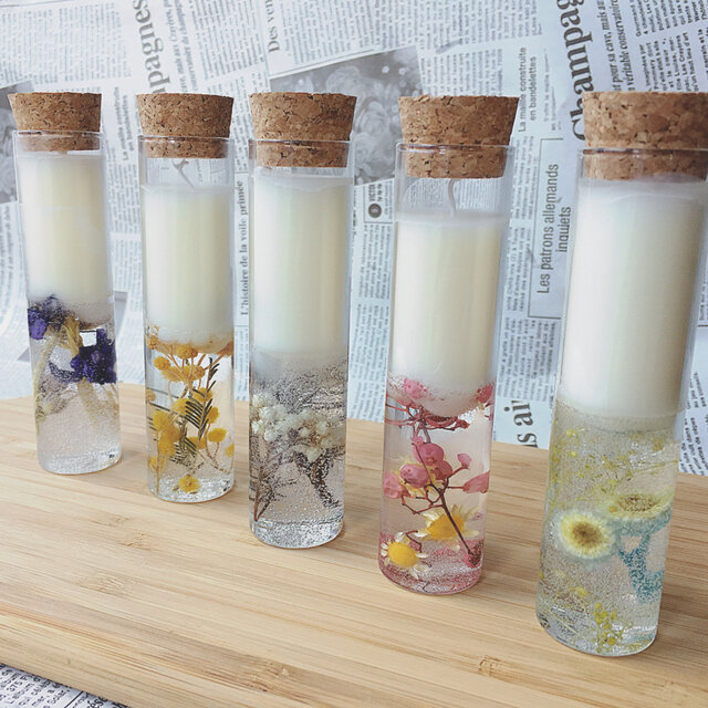 Velas dentro de cápsulas que tienen flores