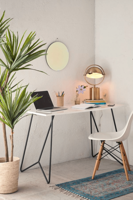 Escritorio con estilo minimalista en tono blanco y planta y lámpara como adorno