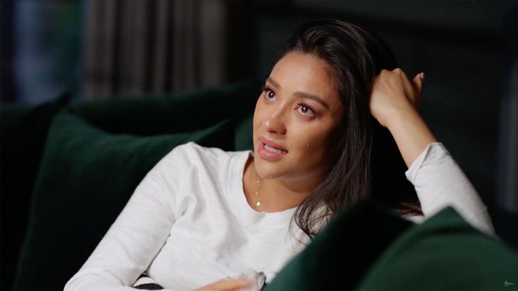 Shay Mitchell sentada en una sala llorando mientras habla de sus hijos