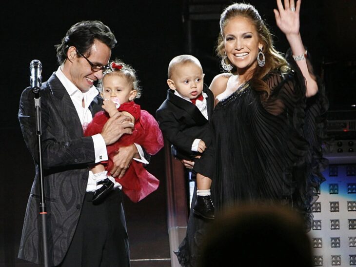 Marc Anthony y Jennifer Lopez cargando a sus mellizos durante una entrega de premios
