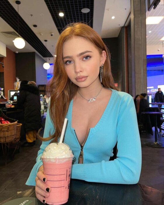 Chica sentada sujetando una malteada