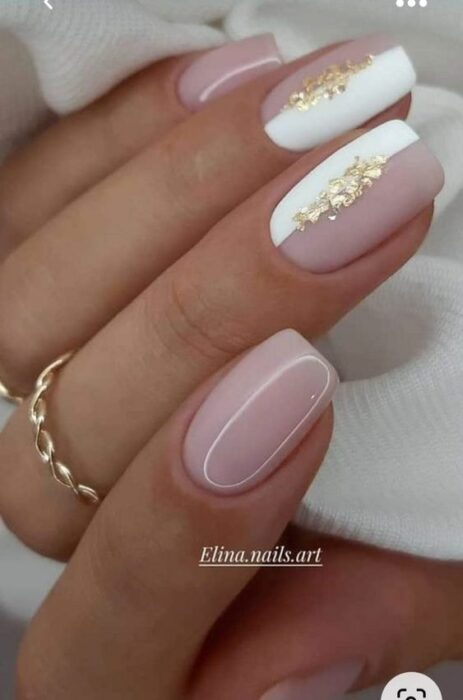 Chica usando unas uñas con tonos dorados brillantes