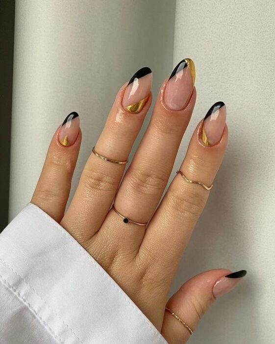 Chica usando unas uñas con tonos dorados brillantes