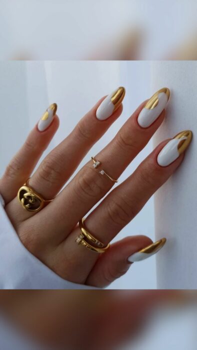 Chica usando unas uñas con tonos dorados brillantes