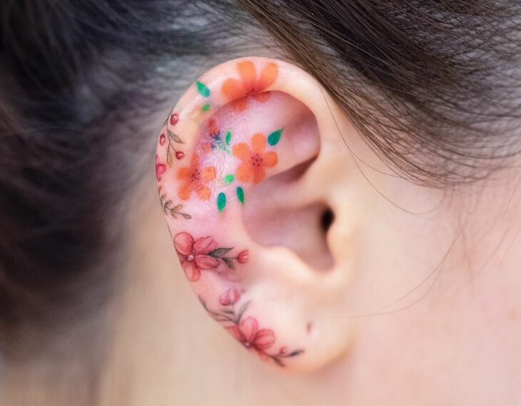 oreja con tatuajes de flores de colores