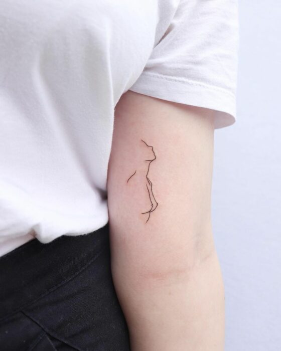 tatuaje de la silueta de una mujer en el antebrazo de una chica