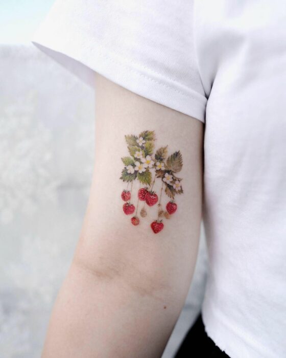 tatuaje de una fresa en el brazo de una chica