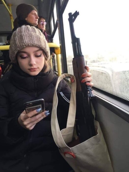 joven con rifle en transporte público ruso