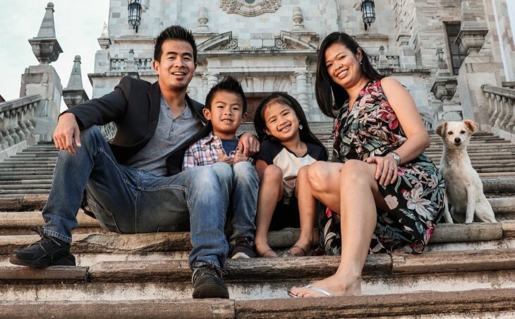 Fotografía de una familia en las escalinatas de la Universidad de Guanajuato, México con un perrito sonriente