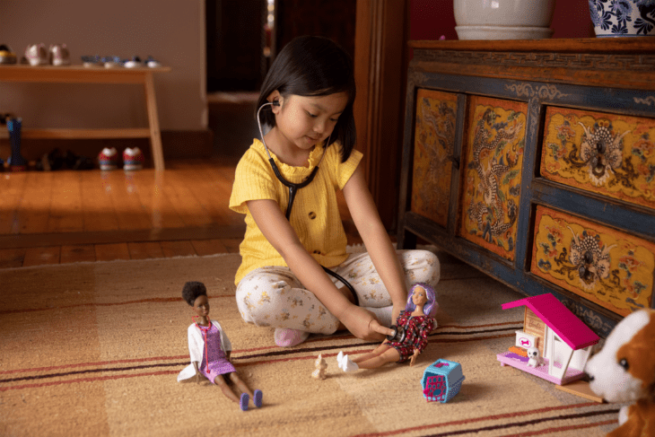 Niña jugando con muñecas Barbie