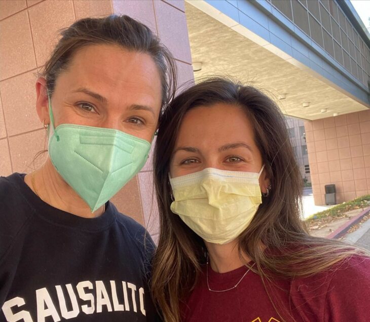 Jennifer Garner junto a un integrante del sector salud fuera de un hospital