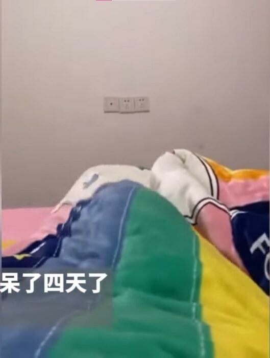 Imagen de unas piernas de una persona cubiertas con una cobija en una cama