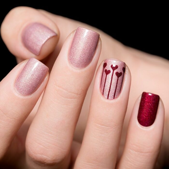 uñas cortas con esmalte rosa y diseño de San Valentín