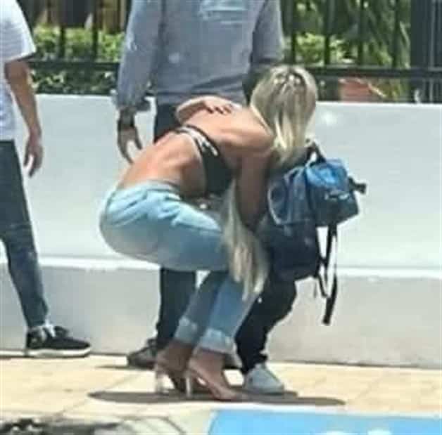 mujer agachada dejando a su hijo en la puerta de la escuela 