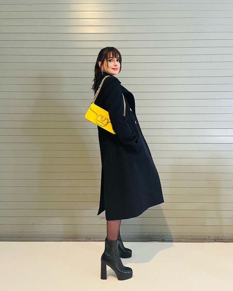 Anne Hataway posando para una fotografía mientras recrea el look de El diablo viste a la moda