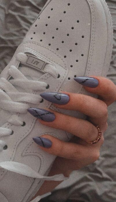 foto de una mano sosteniendo un par de tenis en color blanco