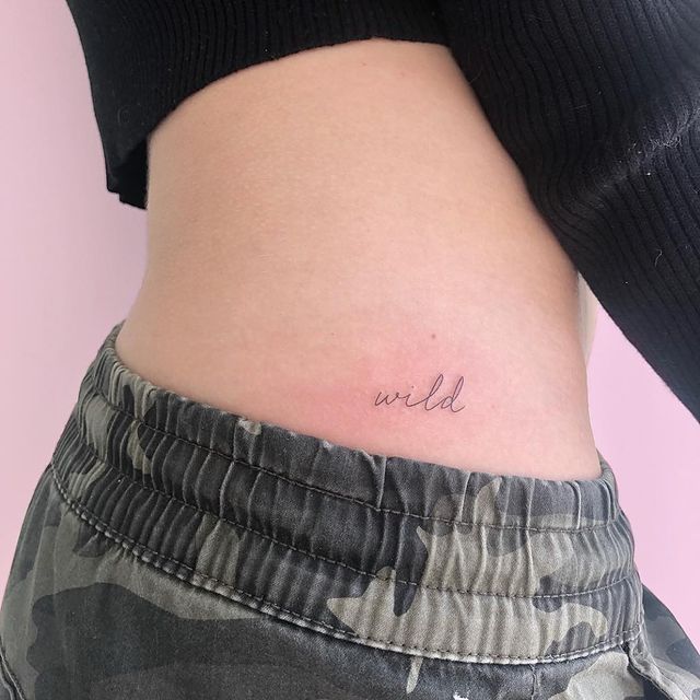 Chica mostrando un tatuaje en la cintura