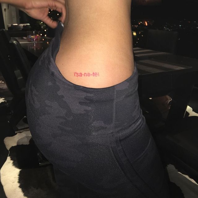 Chica mostrando un tatuaje en la cintura