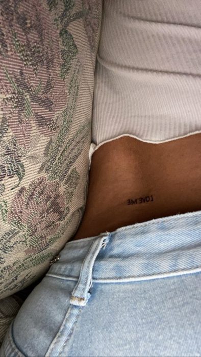 Chica mostrando un tatuaje en la cintura