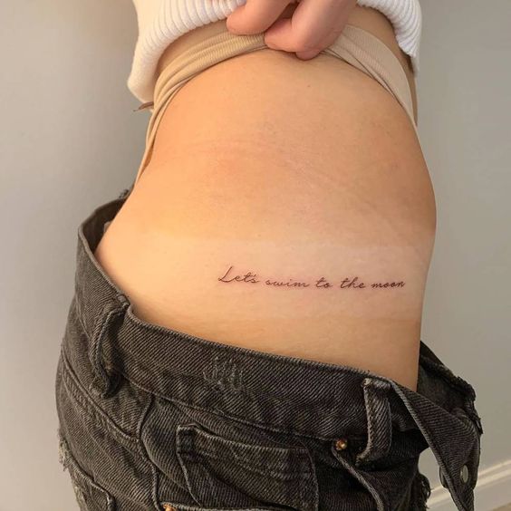 Chica mostrando un tatuaje en la cintura