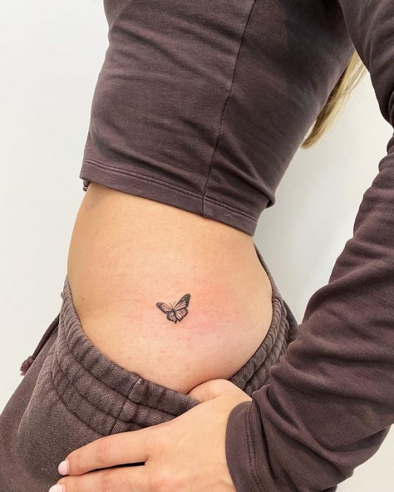 Chica mostrando un tatuaje en la cintura