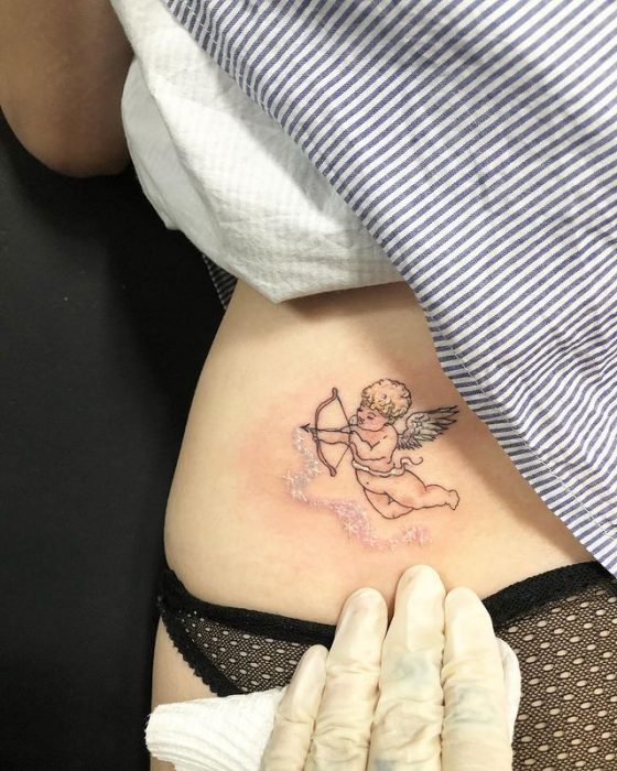 Chica mostrando un tatuaje en la cintura