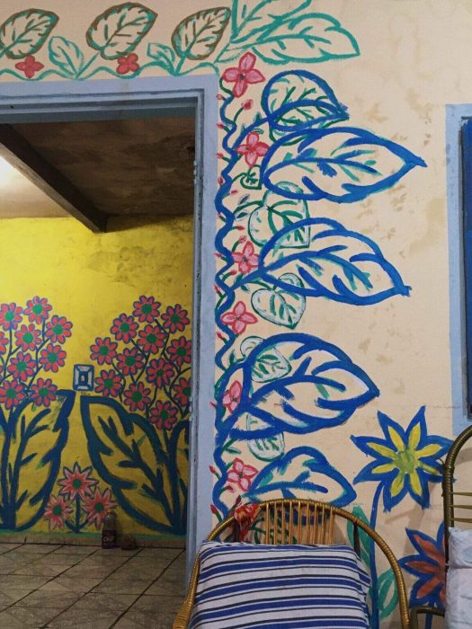 Paredes de una casa con flores y plantas pintadas de diferentes colores