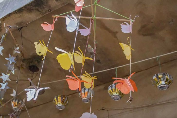 Móviles en forma de mariposa y flores hechos con materiales reciclables