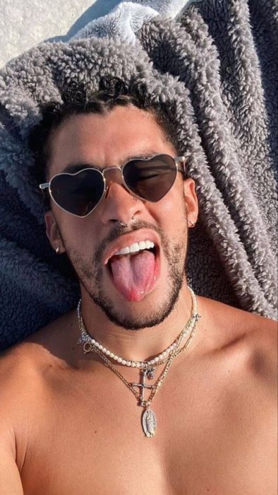 Bad Bunny acostado tomando el sol en la playa