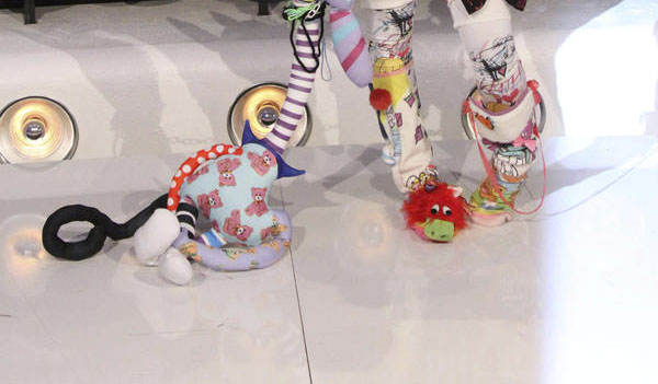 imagen de unos pies cubiertos por calcetas de estampados de colores y un peluche 