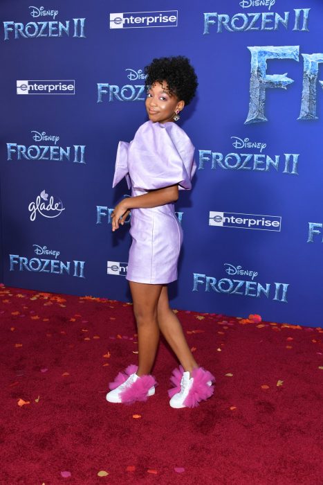 Eris Baker posando con un vestido morado y tenis peculiares durante la alfombra roja de frozen 2
