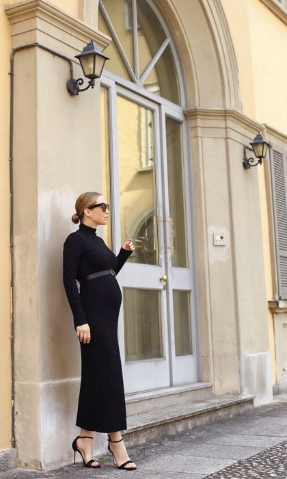 Chica usando un outfit de invierno para presumir con su embarazo