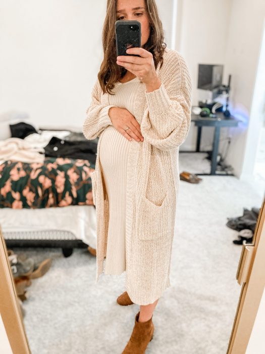 Chica usando un outfit de invierno para presumir con su embarazo