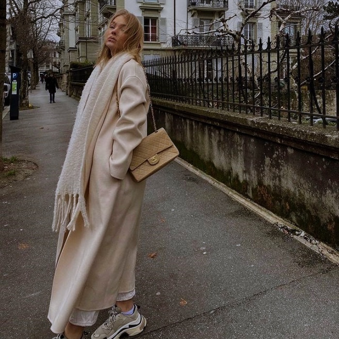 Mujer con abrigo beige y jeans