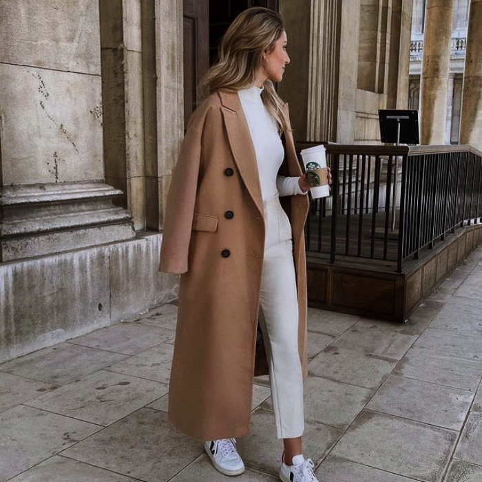Mujer con abrigo beige y jeans