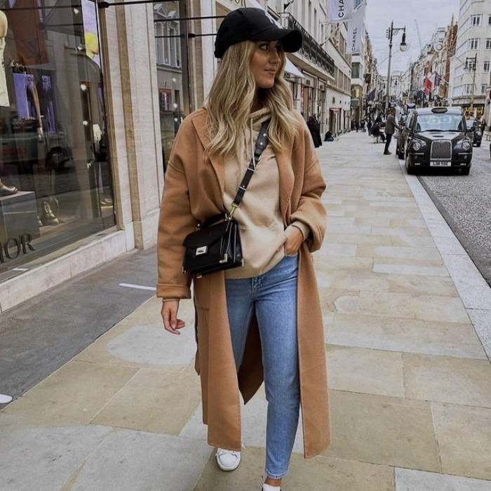 Mujer con abrigo beige y jeans