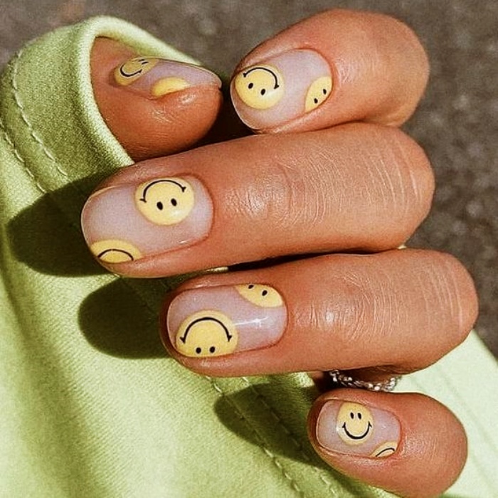 diseño de uñas con caritas felices en amarillo
