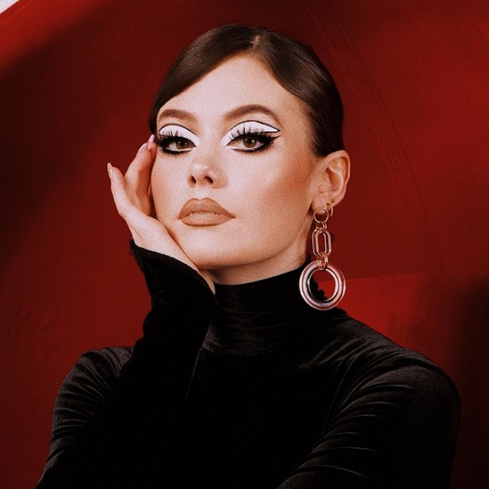 chica con maquillaje, sombras, labial, contour, correcto y pestañas en tonos rosa, azul, rojo y verde para navidad, sombras brillantes, glitter, pestañas postizas, delineado gráfico