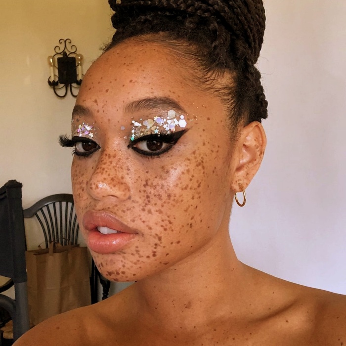 chica con maquillaje, sombras, labial, contour, correcto y pestañas en tonos rosa, azul, rojo y verde para navidad, sombras brillantes, glitter, pestañas postizas, delineado gráfico