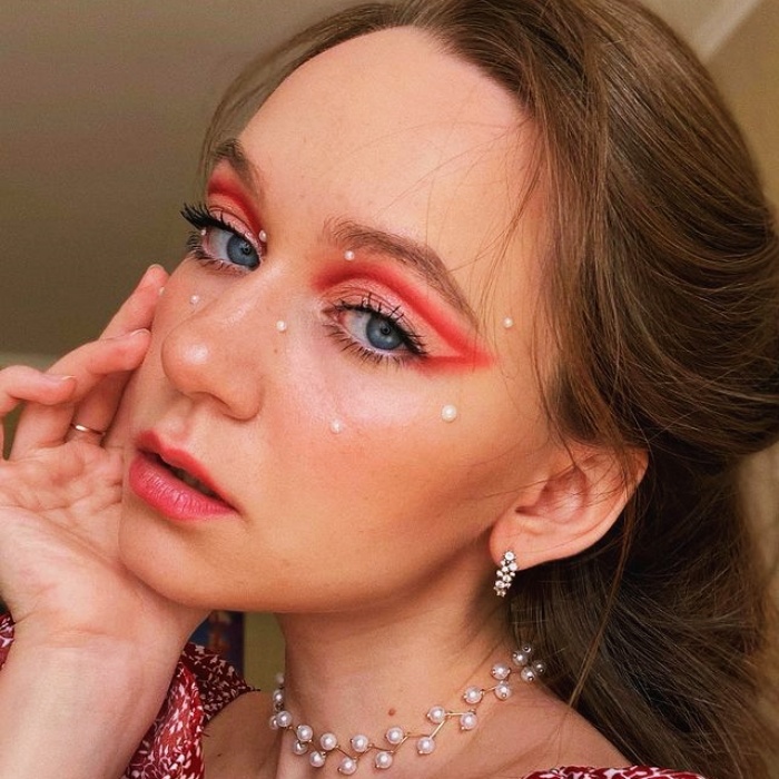 chica con maquillaje, sombras, labial, contour, correcto y pestañas en tonos rosa, azul, rojo y verde para navidad, sombras brillantes, glitter, pestañas postizas, delineado gráfico