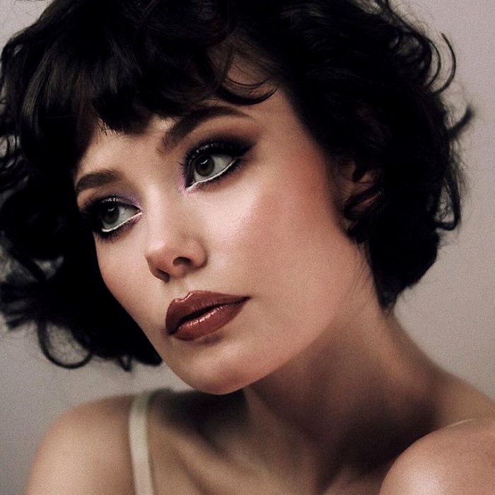 chica con maquillaje, sombras, labial, contour, correcto y pestañas en tonos rosa, azul, rojo y verde para navidad, sombras brillantes, glitter, pestañas postizas, delineado gráfico