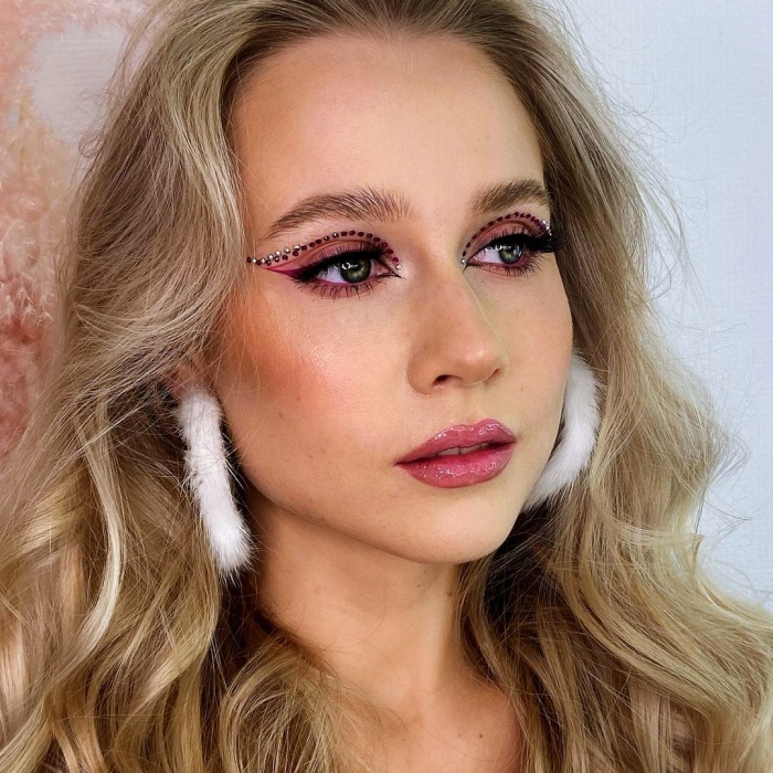 chica con maquillaje, sombras, labial, contour, correcto y pestañas en tonos rosa, azul, rojo y verde para navidad, sombras brillantes, glitter, pestañas postizas, delineado gráfico