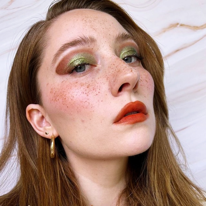 chica con maquillaje, sombras, labial, contour, correcto y pestañas en tonos rosa, azul, rojo y verde para navidad, sombras brillantes, glitter, pestañas postizas, delineado gráfico
