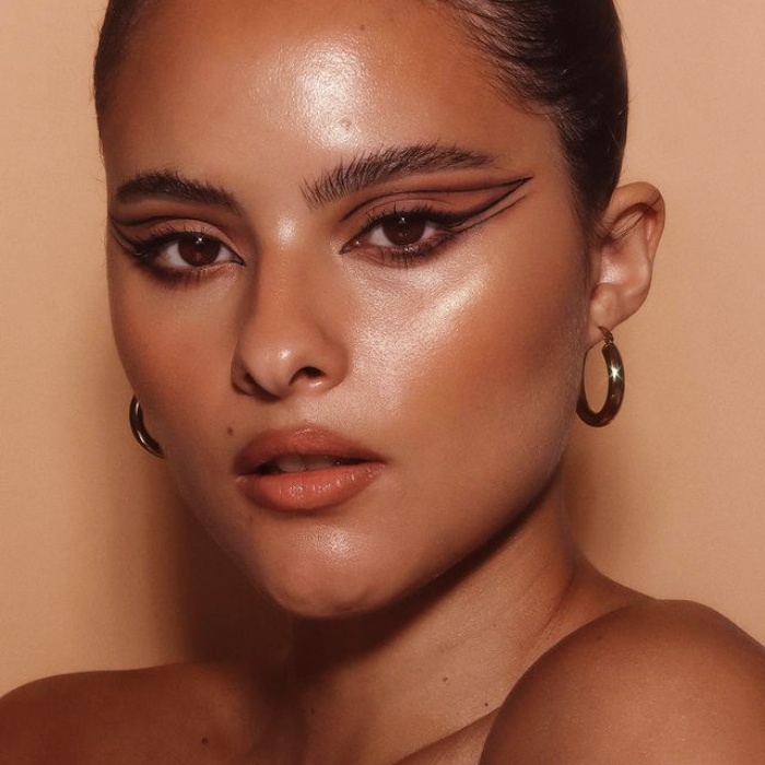 chica con maquillaje, sombras, labial, contour, correcto y pestañas en tonos rosa, azul, rojo y verde para navidad, sombras brillantes, glitter, pestañas postizas, delineado gráfico