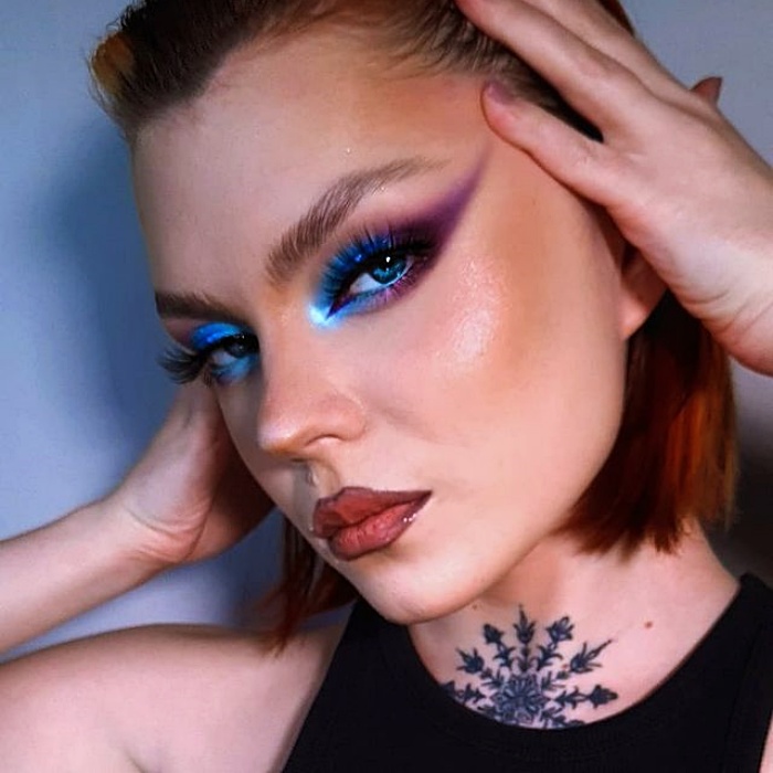 chica con maquillaje, sombras, labial, contour, correcto y pestañas en tonos rosa, azul, rojo y verde para navidad, sombras brillantes, glitter, pestañas postizas, delineado gráfico