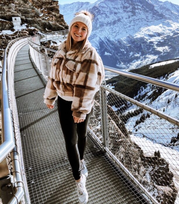 chica, mujer con cabello largo, usando gorro tejido, chamarra, jeans y botas de montaña